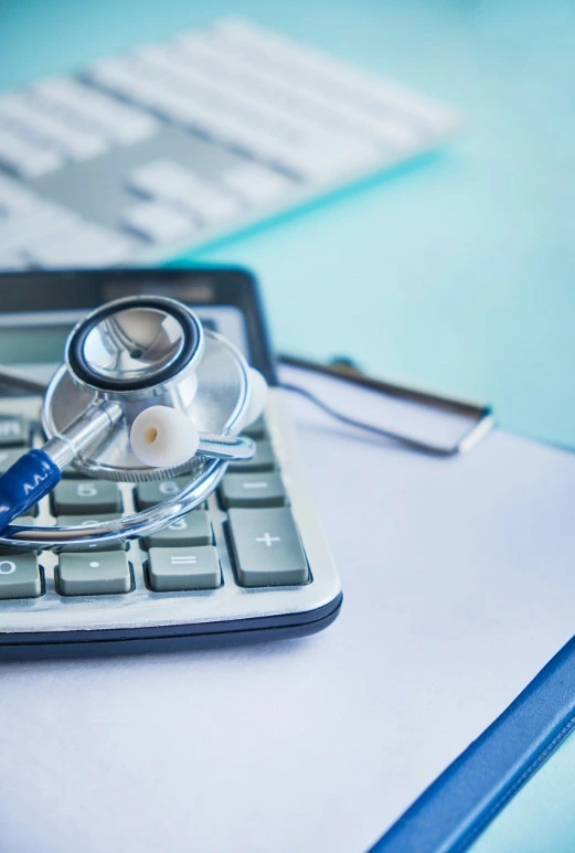 Manos con calculadora y documentos sobre un escritorio, representando la indemnización por negligencia médica